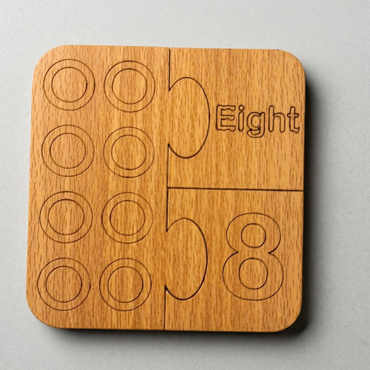 Wooden puzzle piece with 'Eight Five Eight' engraving on a gray background