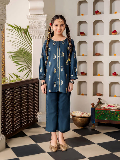 Young girl in a traditional blue outfit standing in a decorative room with shelves and plants.